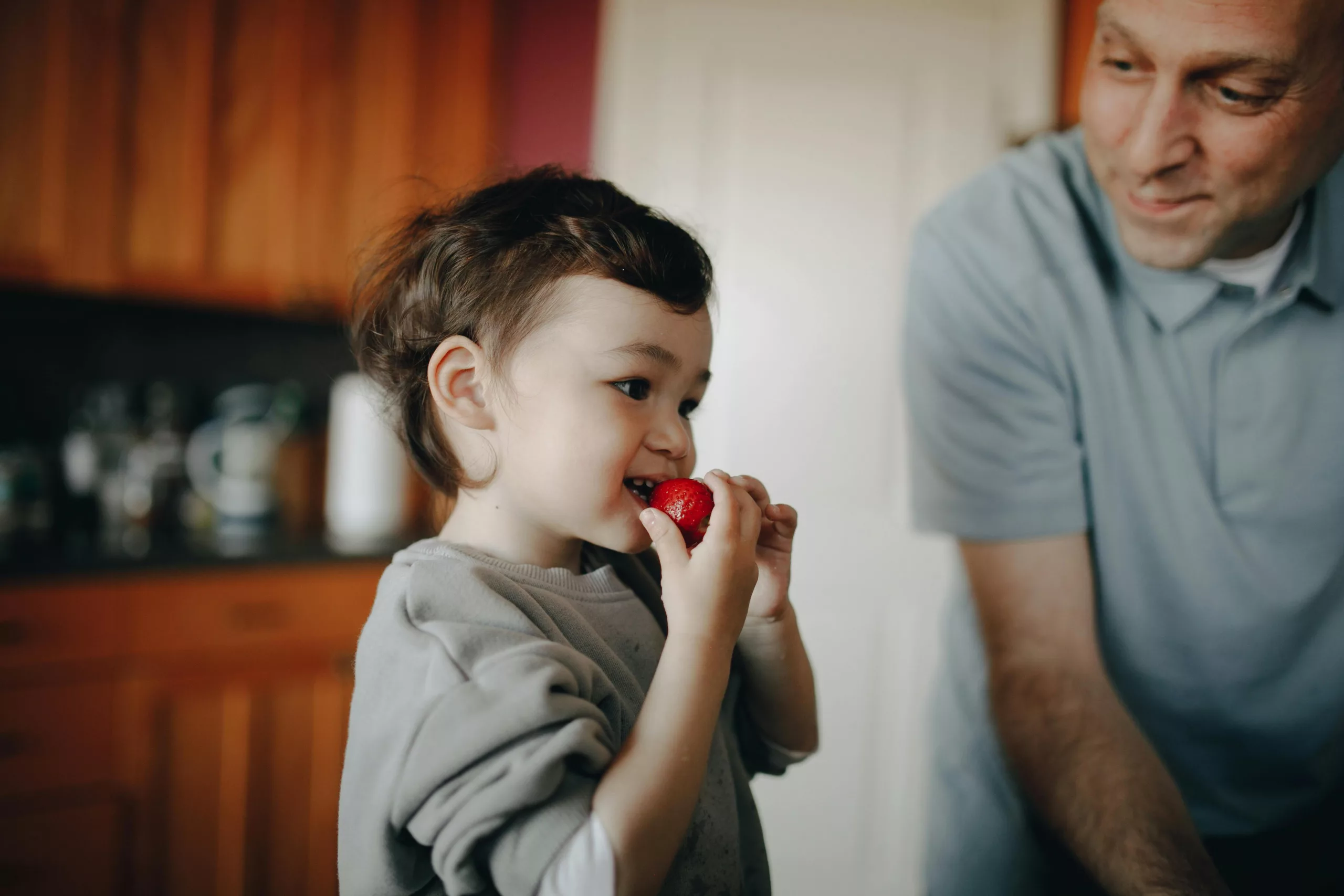 Enfant en train de manger un fruit entier pour le goûter